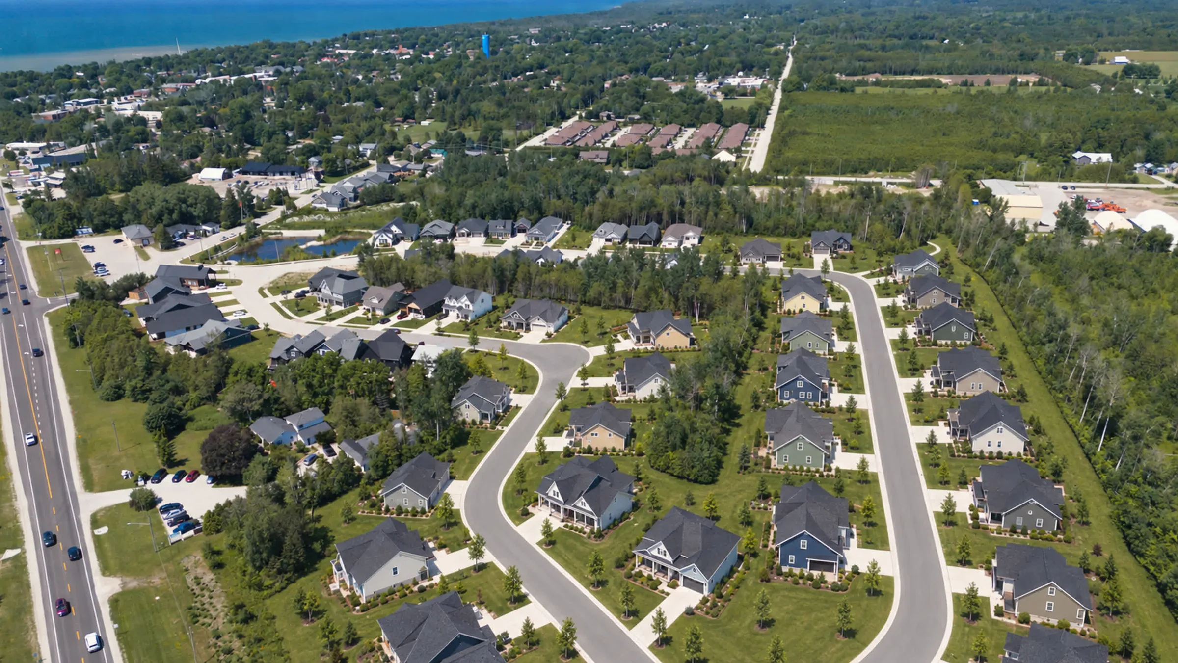 The next phase from above in August 2026: today's vacant plots on the left, and an illustration of the finished street's homes, lawns and young trees on the right