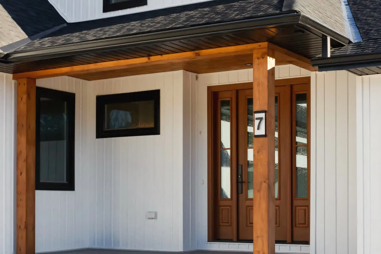 A covered front porch with timber posts and a wood front door, facing the street